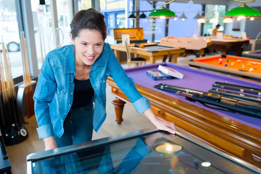 fille qui joue au flipper billard et baby foot